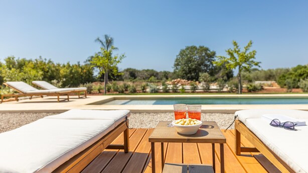 A poolside area with lounge chairs, a table with snacks and drinks, and a clear view of the pool. - Appartamento Cappero - Torre Vado (Torre vado)