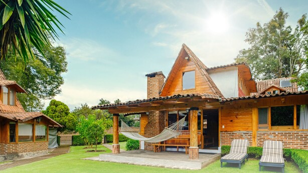 A wooden cabin with a patio, a hammock, and two lounge chairs. - Lujosa Cabaña Privada En Valle de Bravo (Valle de Bravo)