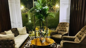 A living room with a sofa, two armchairs, a coffee table, and a patterned rug.