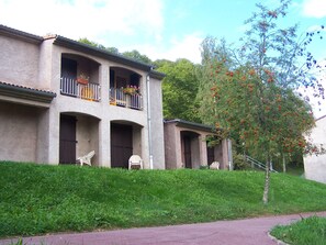 Un bâtiment doté d’un toit plat, de plusieurs balcons et d’un chemin pavé menant à l’entrée.