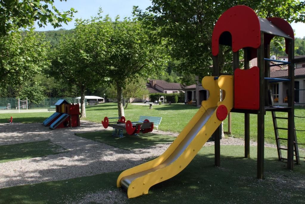 A playground with a yellow slide and a red climbing structure.