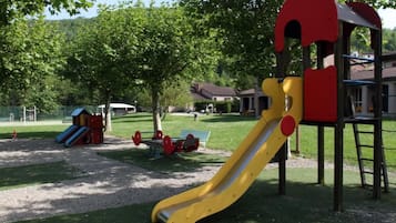 A playground with a yellow slide and a red climbing structure.