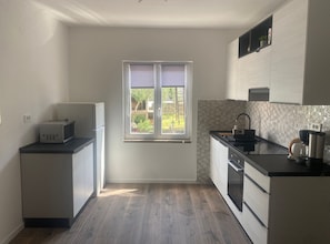 A compact kitchen with a window, a refrigerator, a sink, and a stove. - Apartments Danijela & Vlado (Lopar)