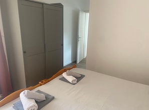 A hotel room with a bed, two towels, and a wardrobe. - Apartments Danijela & Vlado (Lopar)