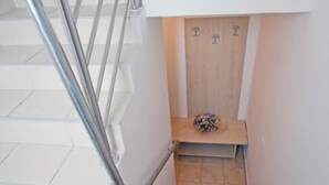 Een smalle trap met een houten bankje aan de voet.