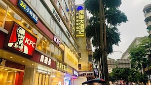 A KFC restaurant with a visible sign and a large building with multiple floors and signage in a commercial area. - Yunfu Jinyu Hotel (Yunfu Bus Station Yihua International Plaza) (Yunfu)