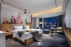 A modern hotel room with a large bed, a desk, and a view of the city skyline at night. - Yunfu Jinyu Hotel (Yunfu Bus Station Yihua International Plaza) (Yunfu)