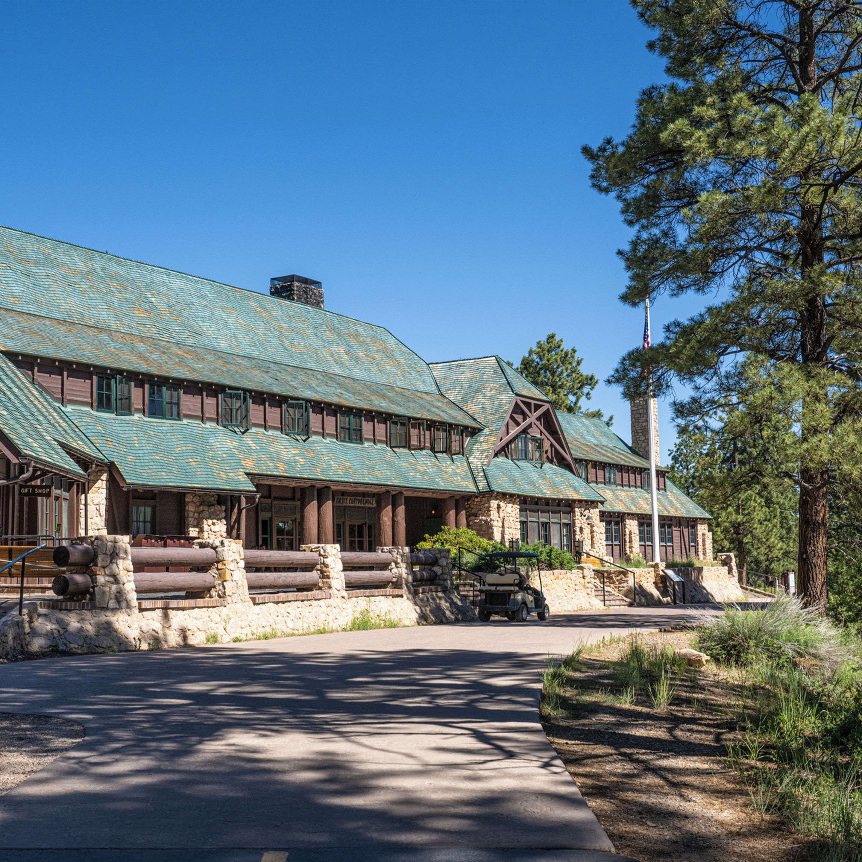 Eine Lodge mit einer Steinfassade, Holzbauweise und einem grünen Metalldach.