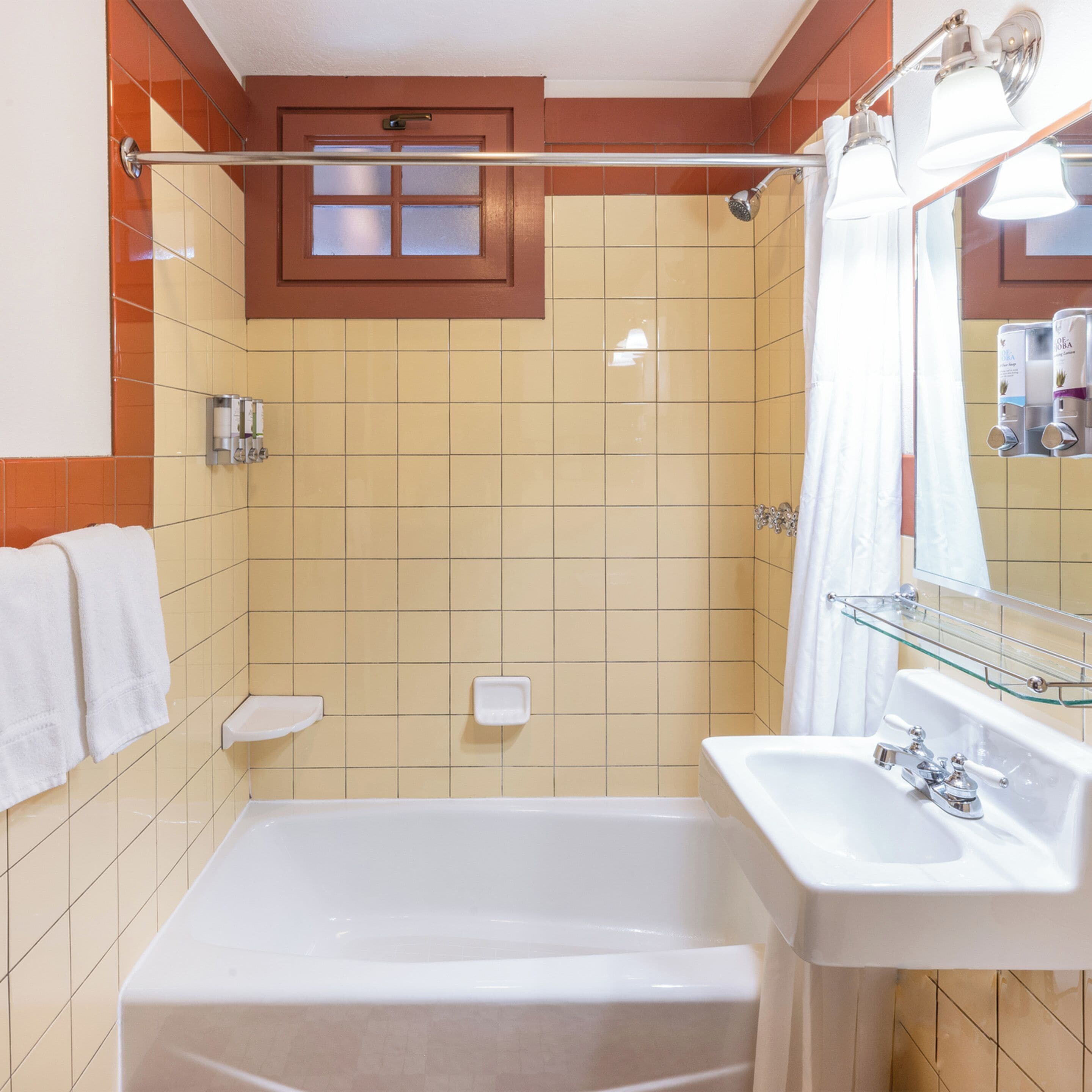 A bathroom with a bathtub, a shower, a sink, and a mirror.