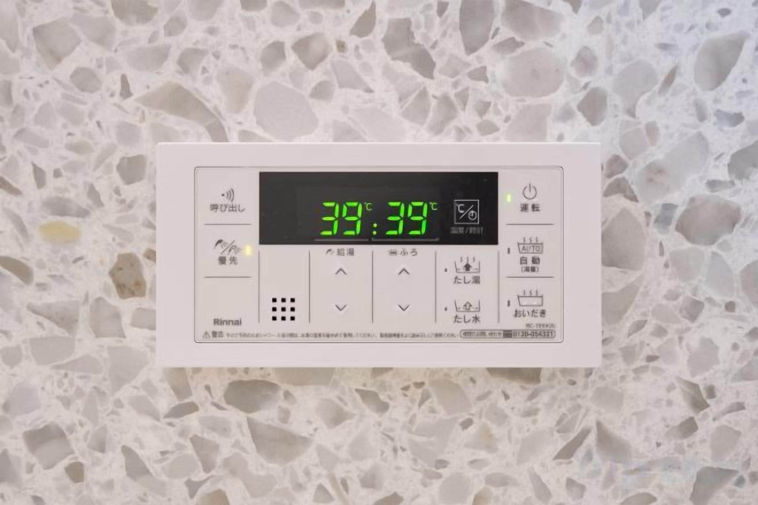 A thermostat with a digital display set to 38 degrees Celsius, indicating room temperature.