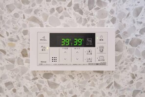 A thermostat with a digital display set to 38 degrees Celsius, indicating room temperature. - Miyoshi House Nonsmoking Self Checkin (Osaka)