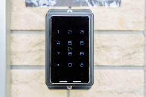 A keypad mounted on a brick wall. - Miyoshi House Nonsmoking Self Checkin (Osaka)