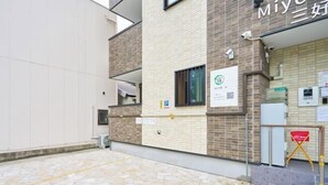 A building with a tiled exterior, a visible parking sign, and a QR code on the wall. - Miyoshi House Nonsmoking Self Checkin (Osaka)
