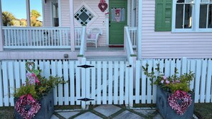A pink house with a white porch, a green door, and a white picket fence. - Home in East End Historic Galveston, Coco Shores (Galveston)