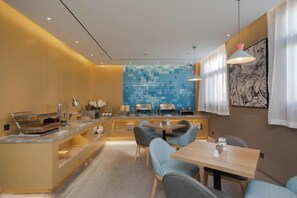 A modern dining area with a long table and chairs, a buffet station, and a blue mosaic wall in the background. - Homeinn Hotel (Beijing ABP World Park Guogongzhuang Subway Station) (Beijing)