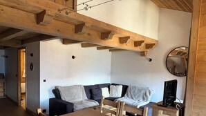 A room with a wooden ceiling, a sofa, a dining table, and a television. - Duplex apartment valley view 4 Bdrm, 3 bed covered parking center of La Rosière (La Rosière)