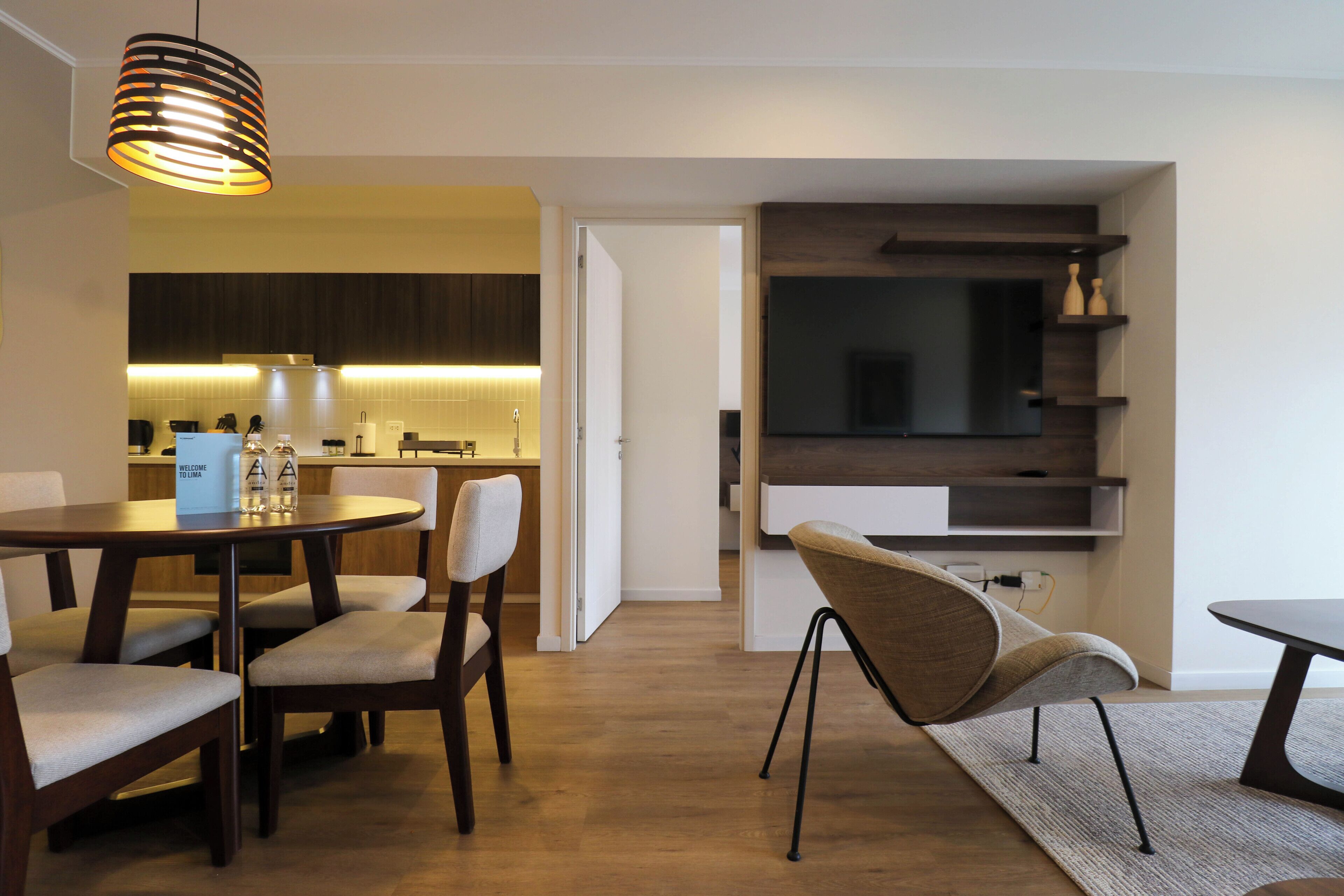 Een moderne eetruimte met een ronde tafel, vier stoelen en een hanglamp.