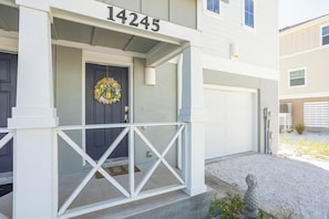 A residential building with a white exterior, a dark front door, and a mailbox. - Cozy & Bright Townhome w/EV Charger-Walk to Beach (Perdido Key)