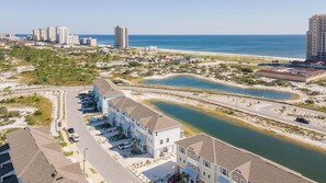 Ein Küstenhotel mit mehreren Gebäuden, einer Straße und einem Strand im Hintergrund.