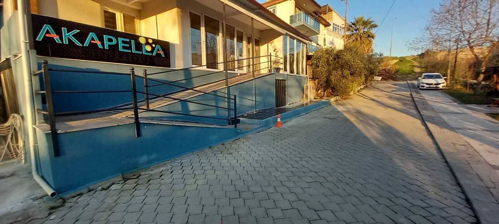 A building with a blue facade and a sign reading "AKAPELLA".