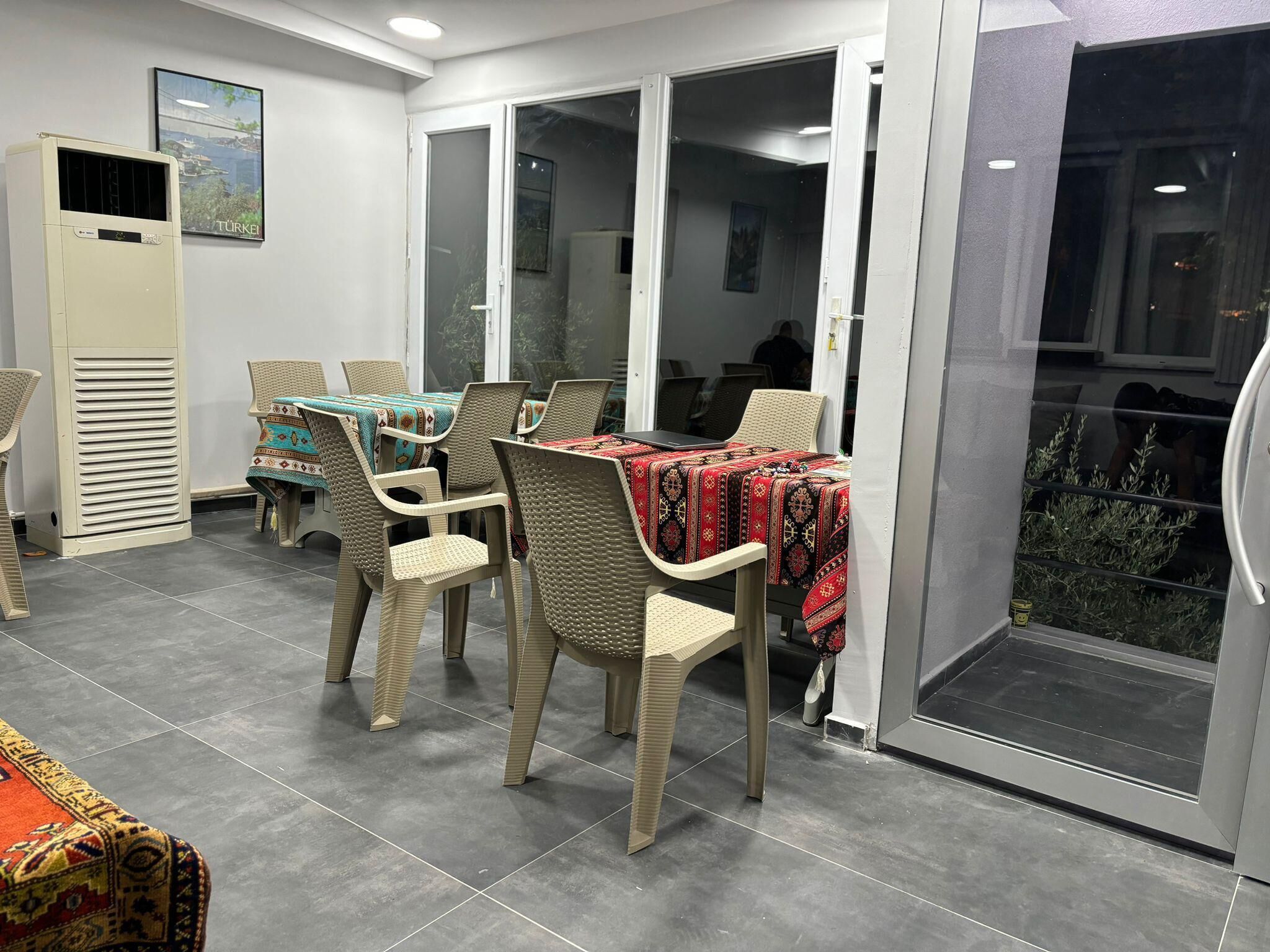 Un comedor con una mesa y sillas, un calefactor y vistas a través de puertas de vidrio.