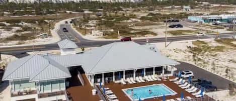 A cruise ship with a pool area, lounge chairs, and a covered deck.