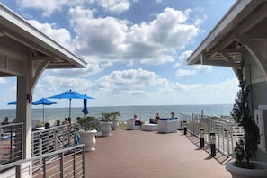 Een terras met zitplaatsen en parasols met uitzicht op zee.