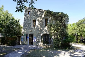 Un edificio de piedra con puerta, ventanas y un cartel.