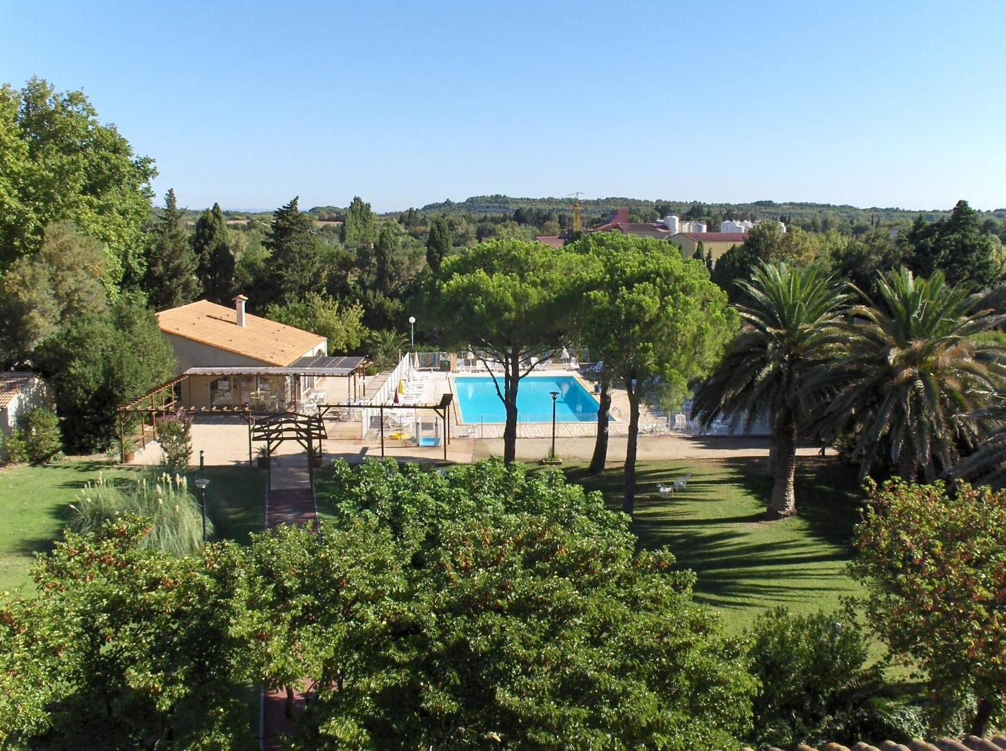 Un espace piscine offrant une vue dégagée sur le paysage environnant, notamment sur les arbres et une colline au loin.
