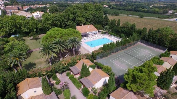 An aerial view of a residential area with a swimming pool, tennis court, and surrounding greenery. - Vvf Villages Sigean (Sigean)
