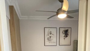 A bedroom with a bed, a ceiling fan, and two framed pictures on the wall. - Apartamenty na Wydmach BR (Międzywodzie)