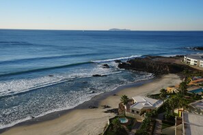 A coastal property with a beach, ocean view, and a swimming pool. - The Pacibeach Condo • Oceanfront • Infinity View (Playas de Rosarito)