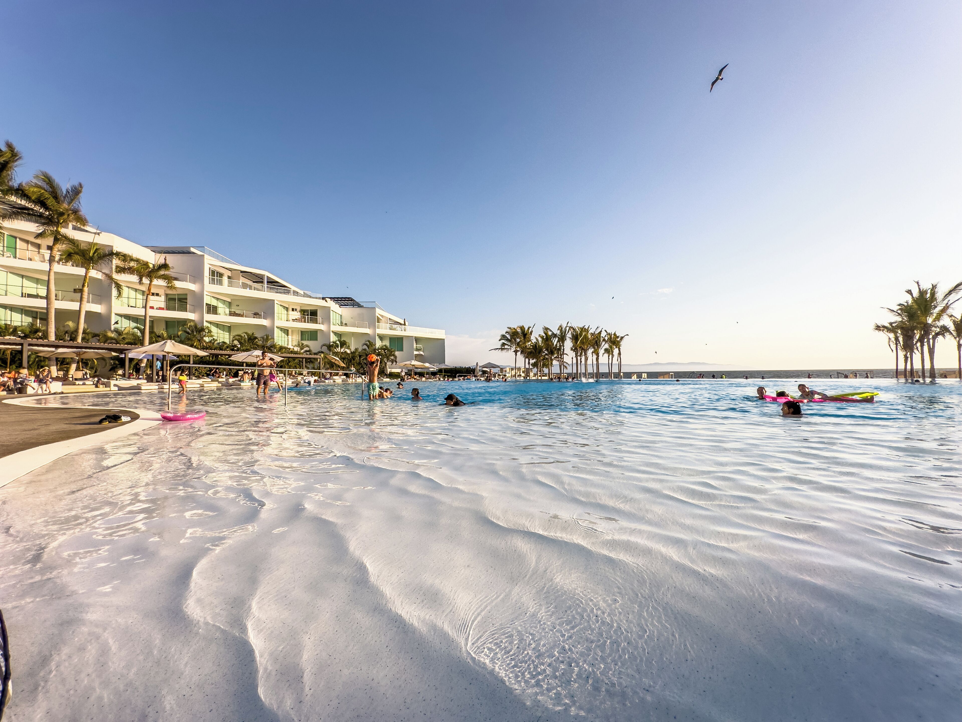 Alberca al aire libre, sombrillas en la alberca y camastros 