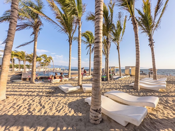 Privat strand, vit sandstrand, solstolar och parasoller