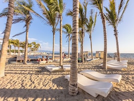 Playa privada, arena blanca, sillas reclinables de playa, sombrillas