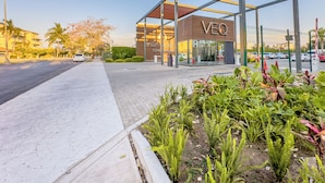 Un edificio moderno con fachada de vidrio y un cartel que dice "VEQ".