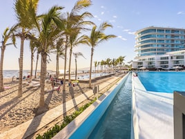 Una piscina al aire libre, sombrillas, tumbonas