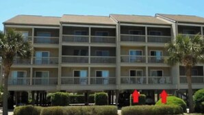 Un hotel de varios pisos con balcones, techo plano y fachada simétrica.
