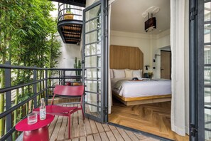 Una stanza moderna con un letto, una sedia rossa e un tavolo con una bottiglia e un bicchiere.