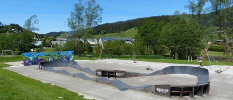 A skate park with ramps and a mural.