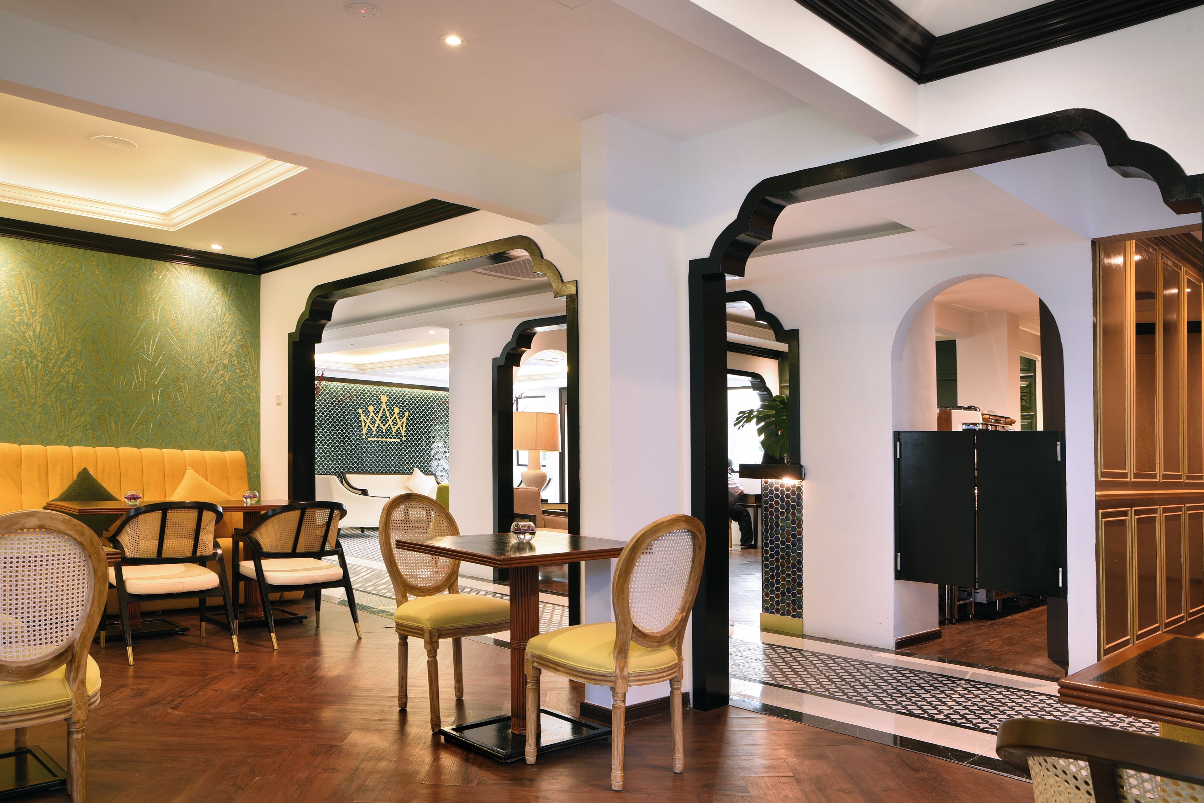 A hotel lobby with a seating area, a reception desk, and a staircase.