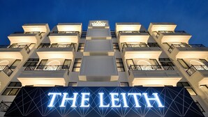 A hotel with a prominent illuminated sign reading "THE LEITH" and a modern architectural design with multiple balconies. - The Leith (George Town)