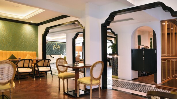 A dining area with wooden furniture and a green accent wall. - The Leith (George Town)
