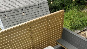 A hot tub on an outdoor deck with a wooden fence and a bench. - STAY WITH US, Brand New, 8 BR, 4 Bth, 1/2 mi to Okemo, Hot Tub, on Shuttle, King (Ludlow)