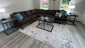 A modern living room with a sectional sofa, a coffee table, and a rug. - STAY WITH US, Brand New, 8 BR, 4 Bth, 1/2 mi to Okemo, Hot Tub, on Shuttle, King (Ludlow)