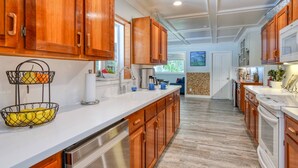 A kitchen with wooden cabinets, a white countertop, and a stainless steel dishwasher. - Casa Contera (St. Augustine)