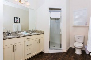 Une salle de bain équipée d’une douche, de toilettes et d’un meuble-lavabo avec un miroir.