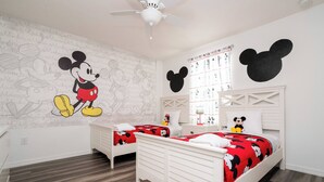 A children's room with Mickey Mouse-themed decor, including wall art, bedding, and a headboard. - Lake View Home With Private Pool at Bella Vida 91 (Kissimmee)