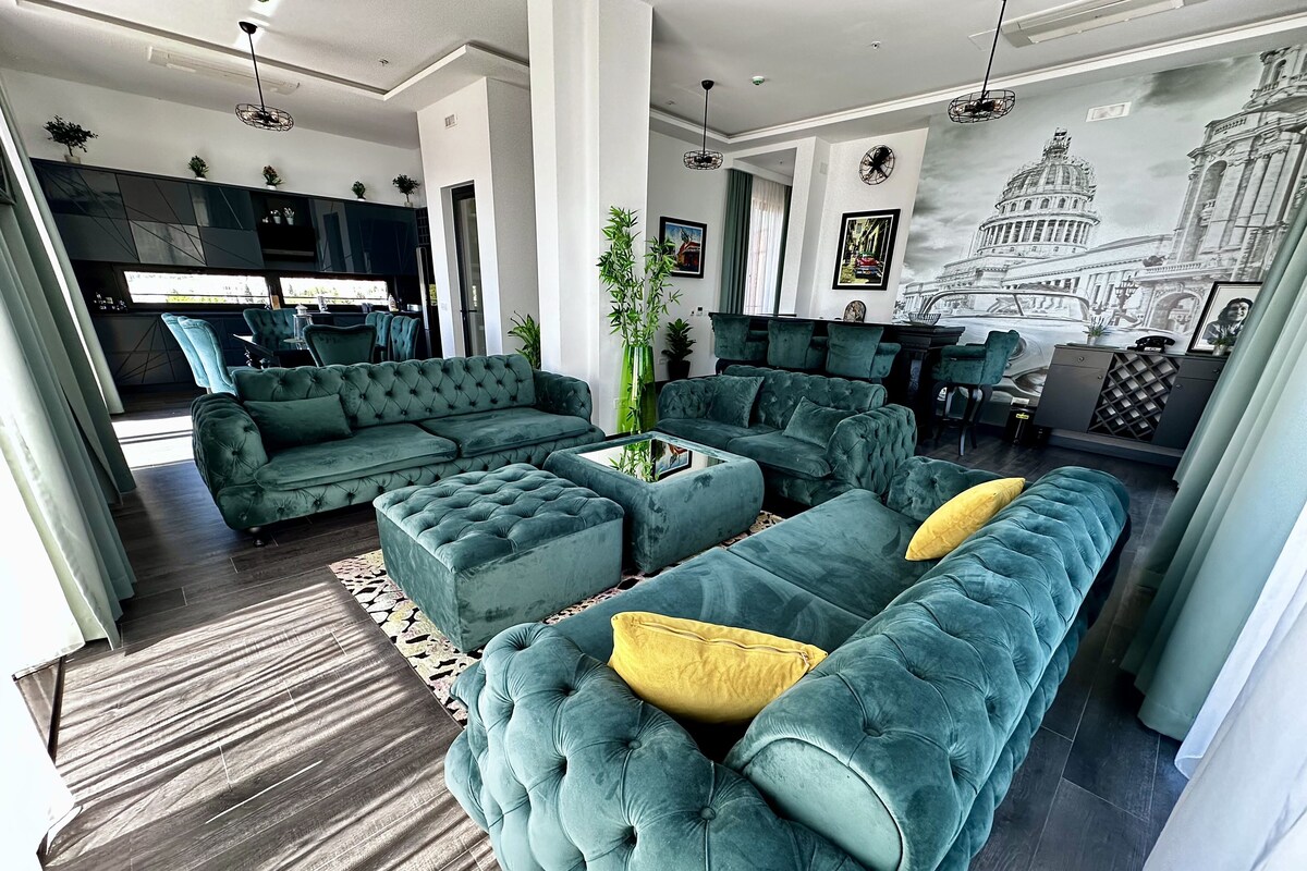 A modern living room with a sectional sofa, a coffee table, and a dining area.