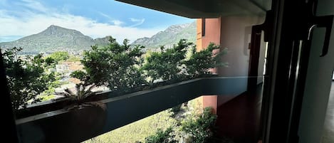 A balcony with a view of a mountainous landscape and a building in the background.